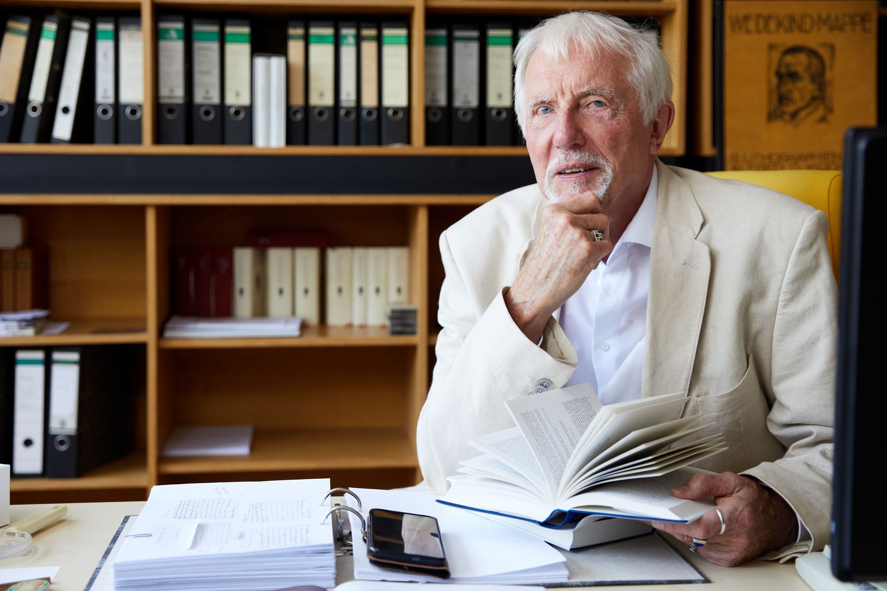 Portraitfoto von Prof. Vincont in seinem Büro, im Hintergrund Bücher und Leitzordner