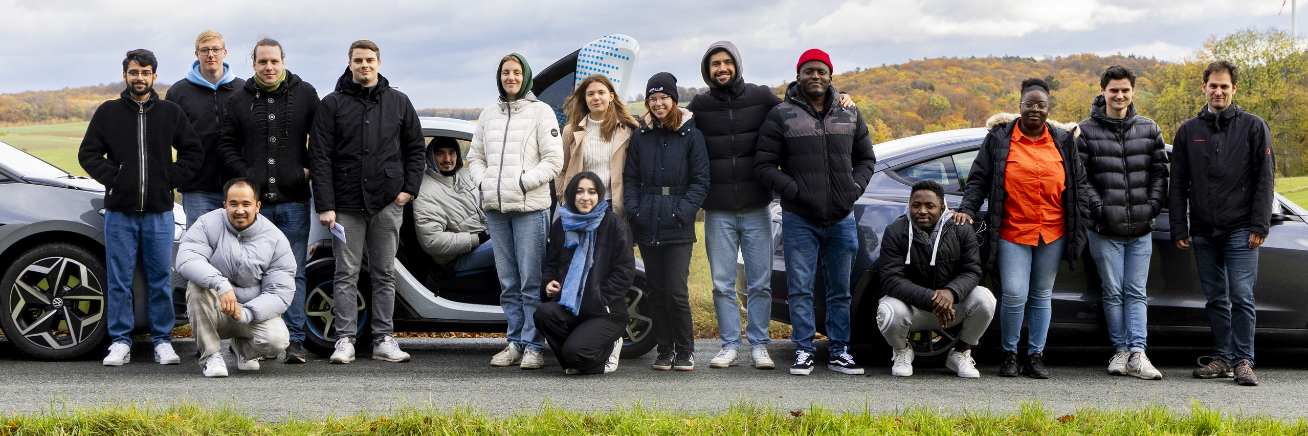 Studierendengruppe mit E-Autos auf einer Bergkuppe im Odenwald