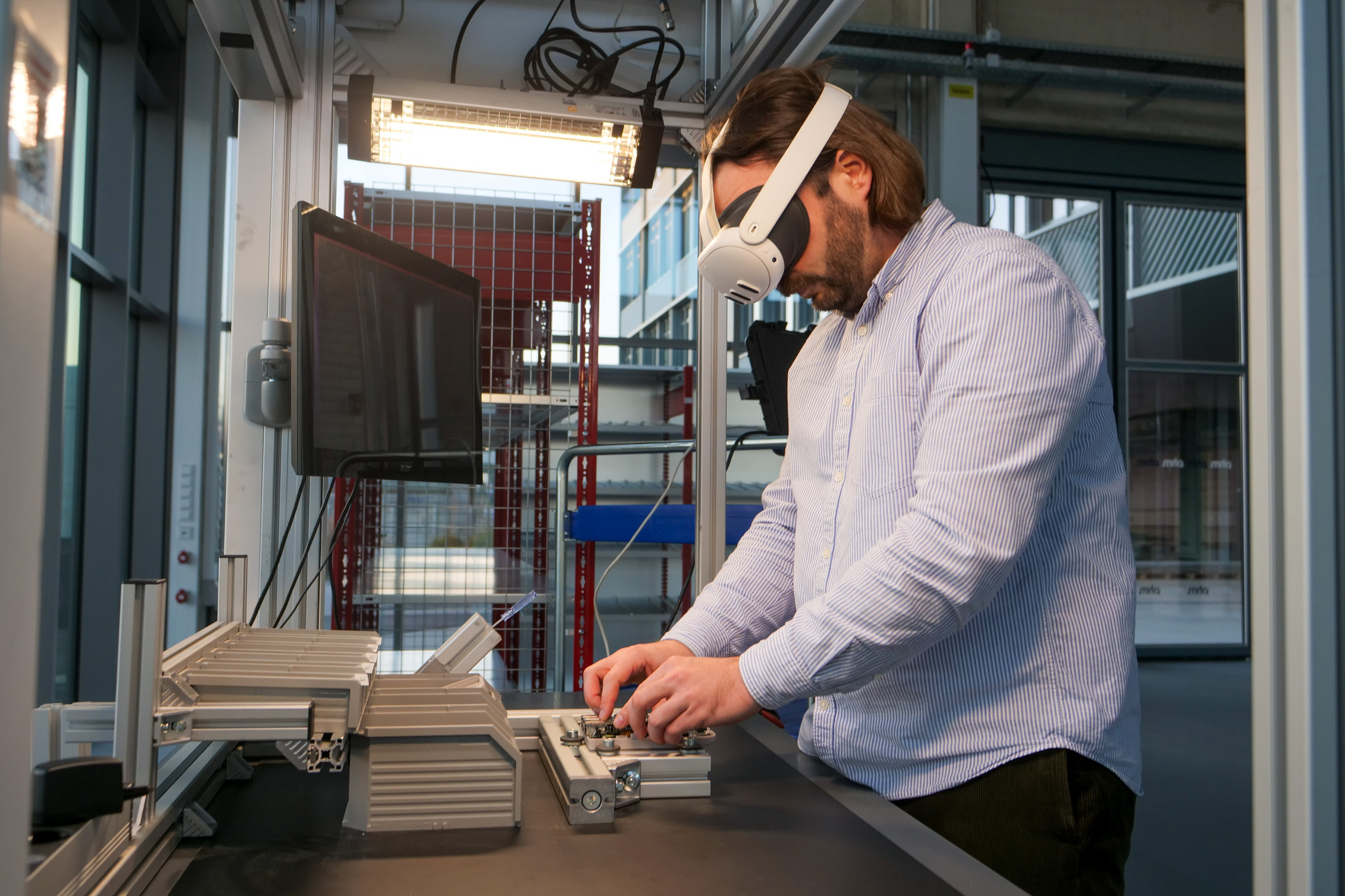 Fabian Sturm mit VR-Brille bei der Montage an einer Werkbank