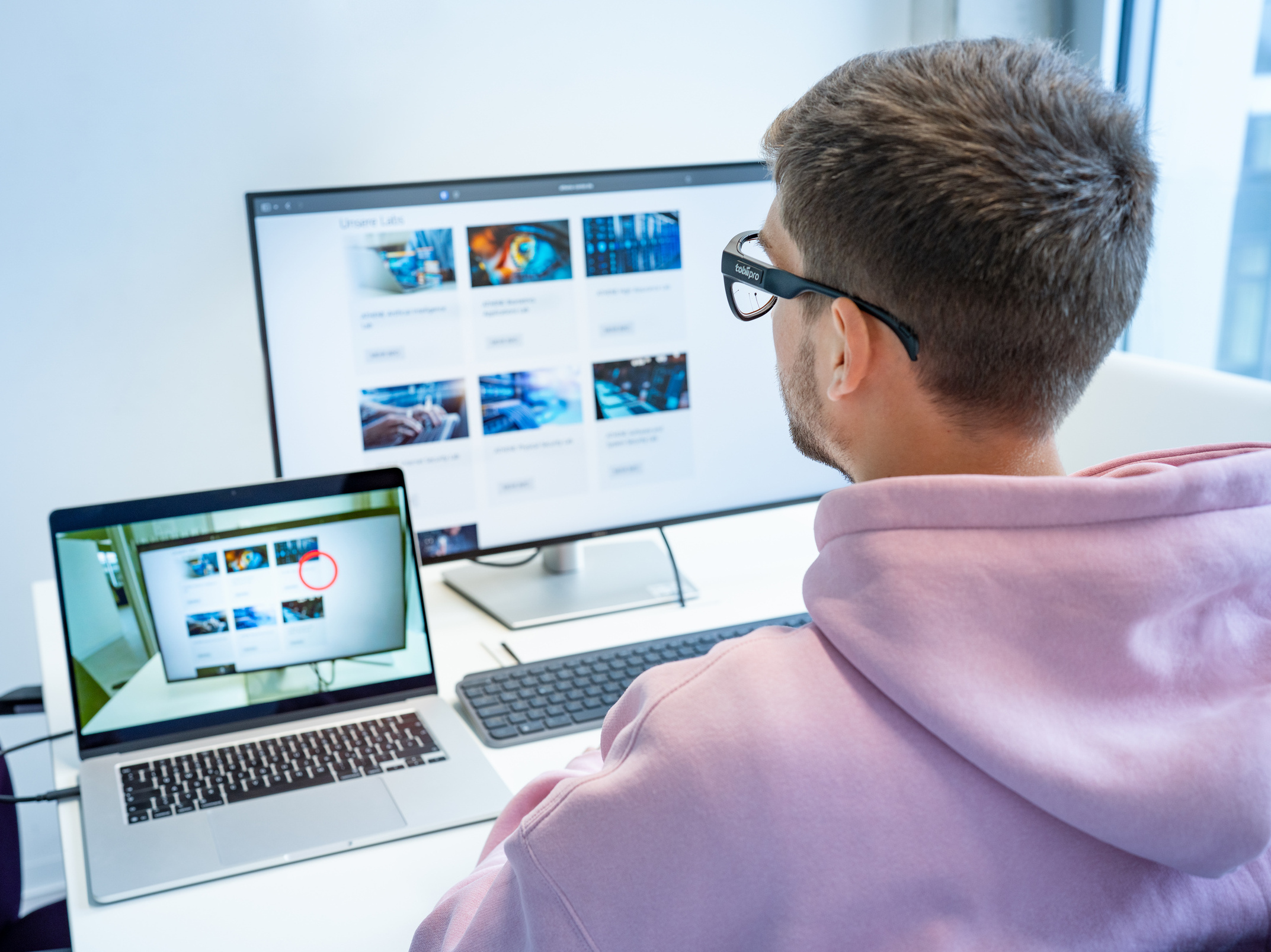 Junger Mann in einem Versuch-Setup vor Bildschirmen