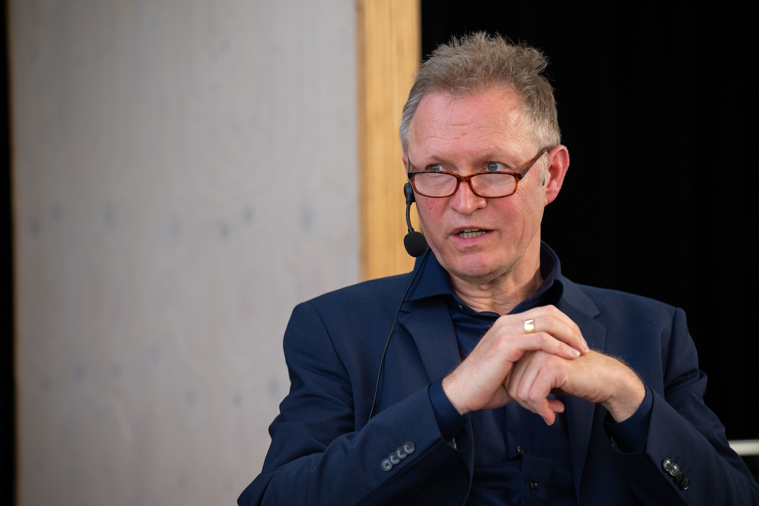 Moderator Thomas Döring stellt eine Frage und blickt die Adressatin an.