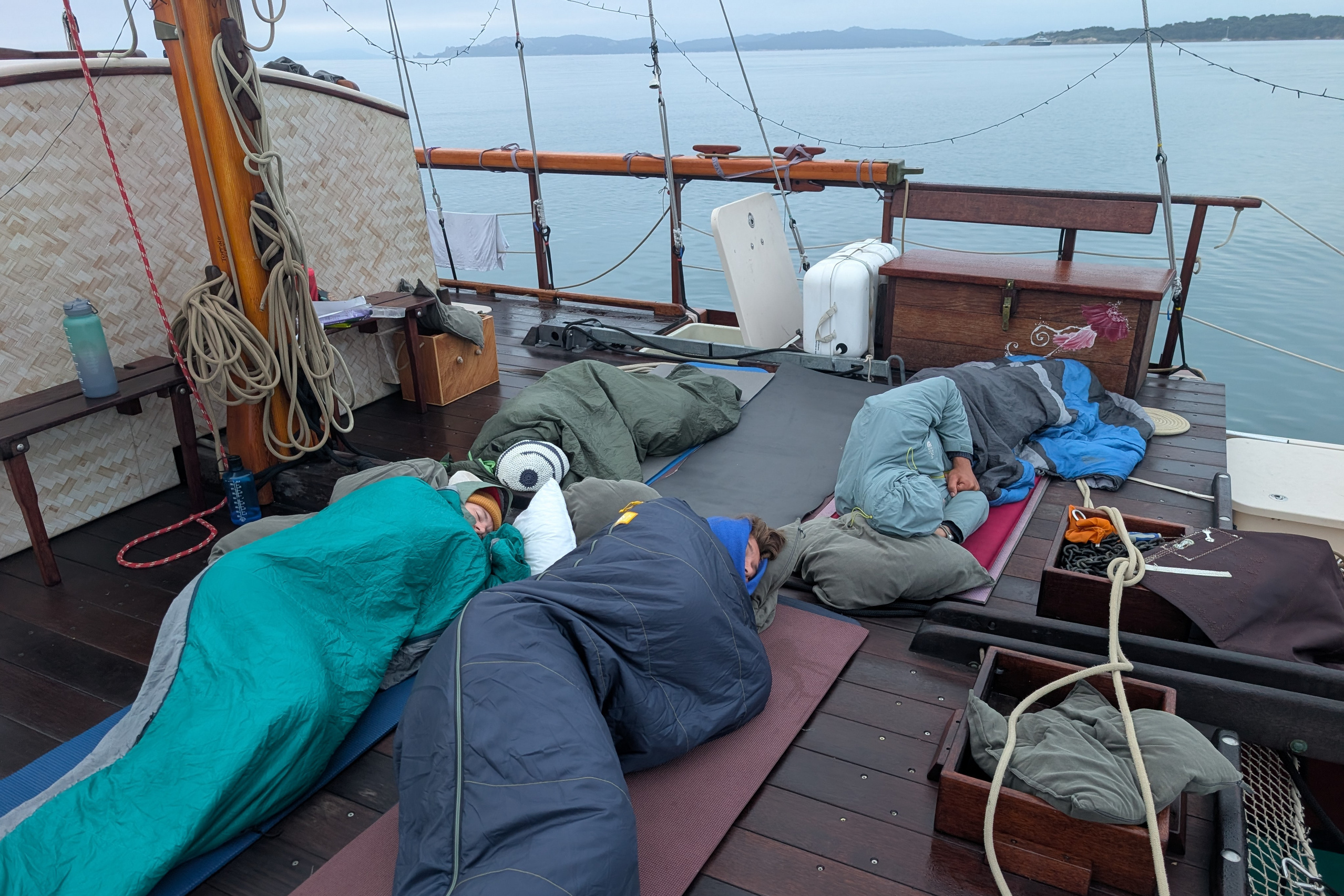 Studierende in Schlafsäcken an Deck