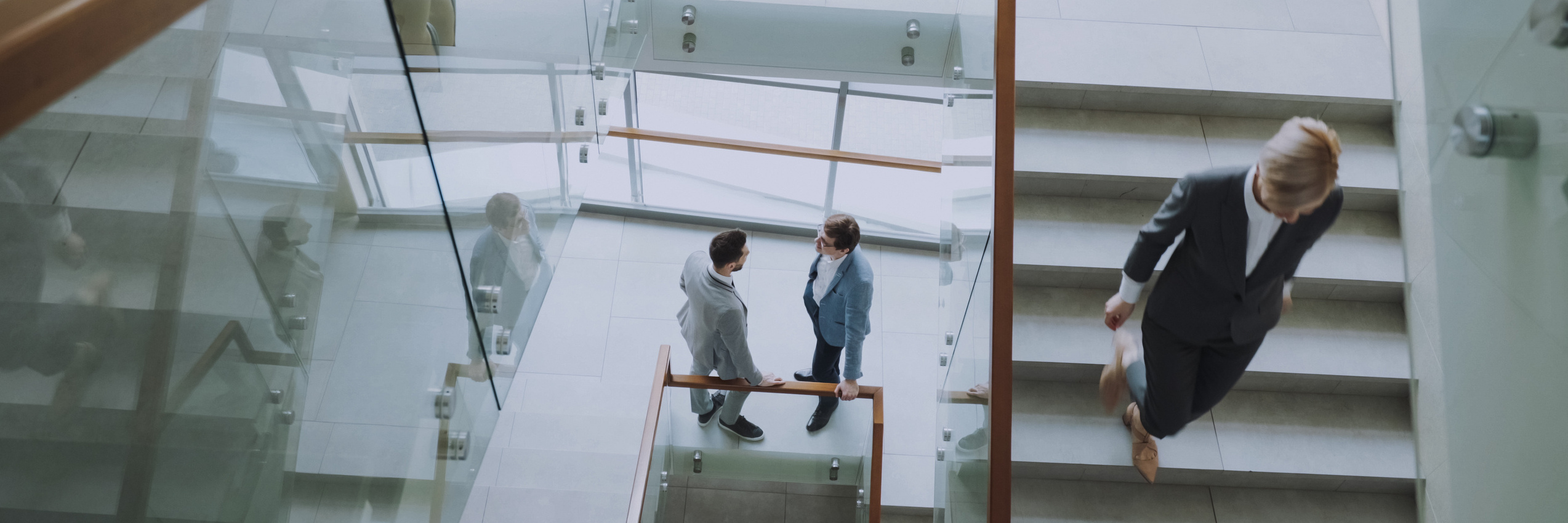 Szene mit Personen im Treppenhaus eines Bürogebäudes
