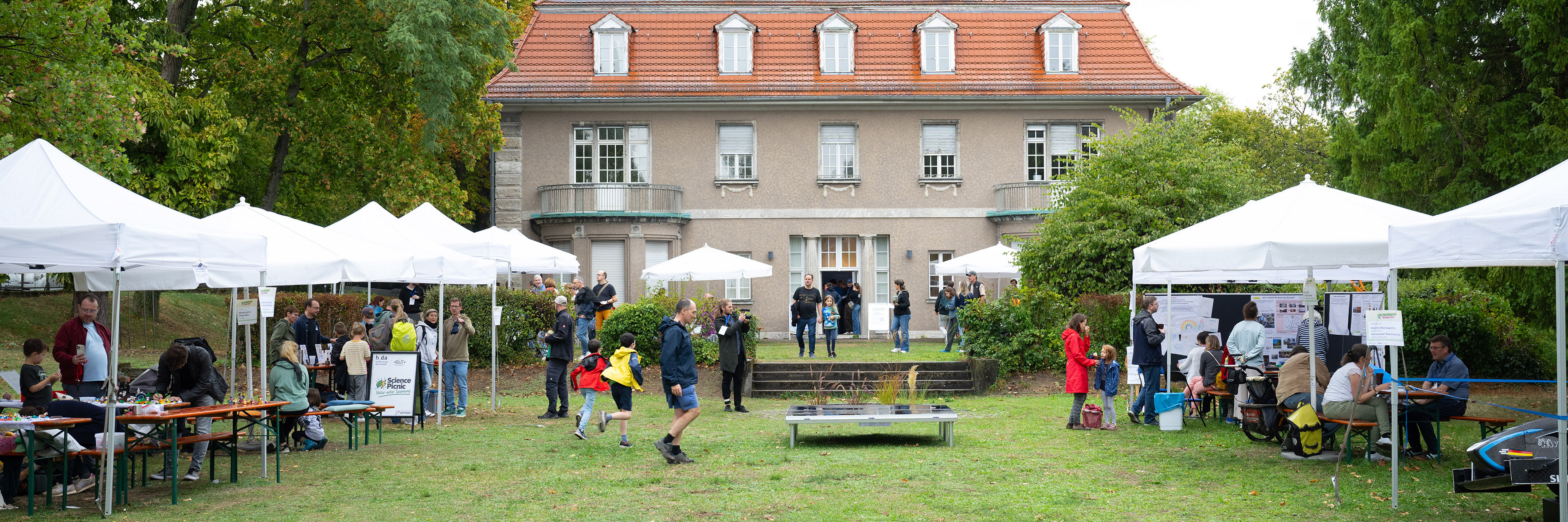 A rear view of the Design House from the garden, showing the pavilions and guests