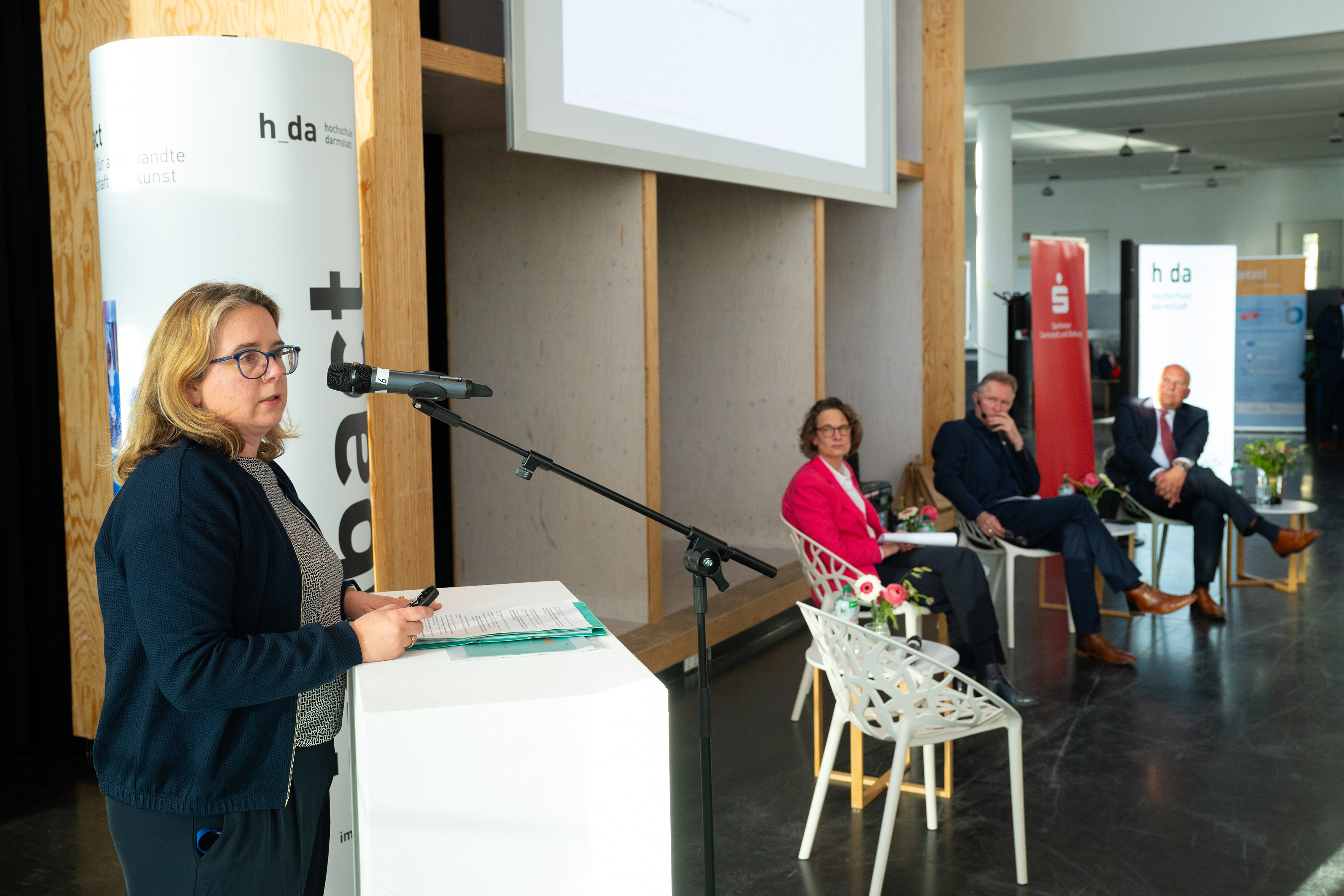Blick auf Charlotte Dany von der h_da, die am Podium ihren Kurzvortrag hält.