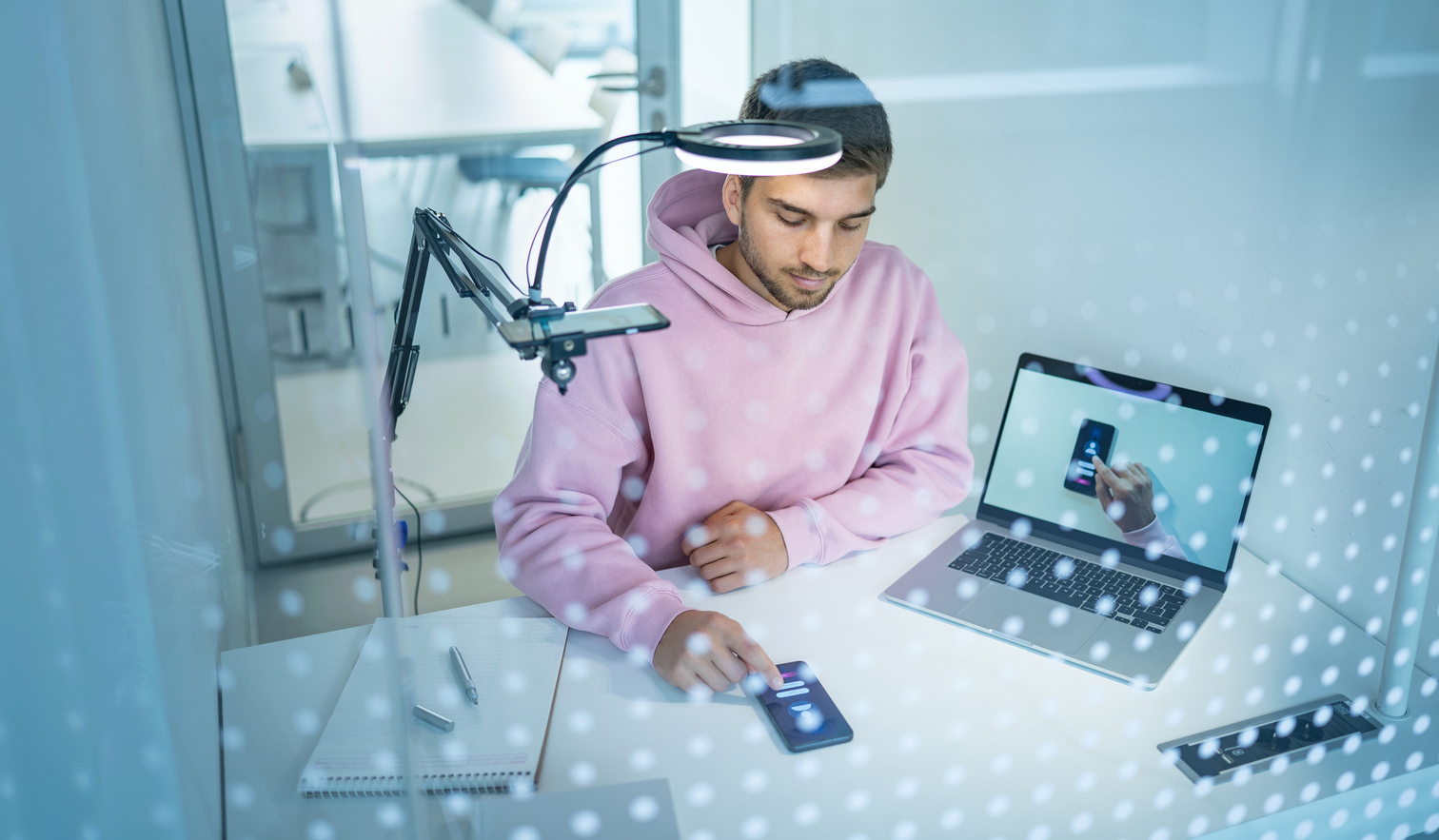 Young man in an experimental setup with mobile phone, laptop and overhead camera