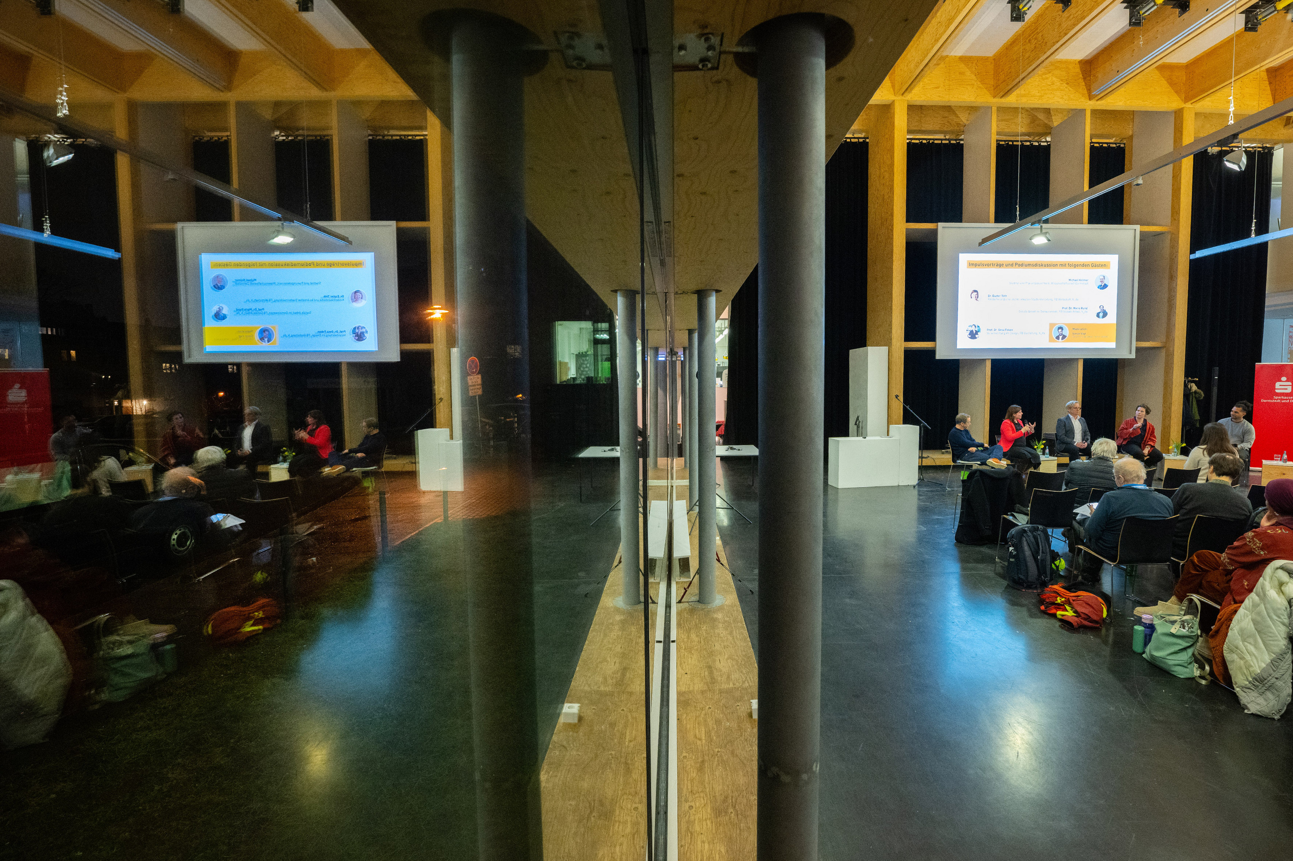 Symmetrical shot in which the hall is reflected in the glass façade