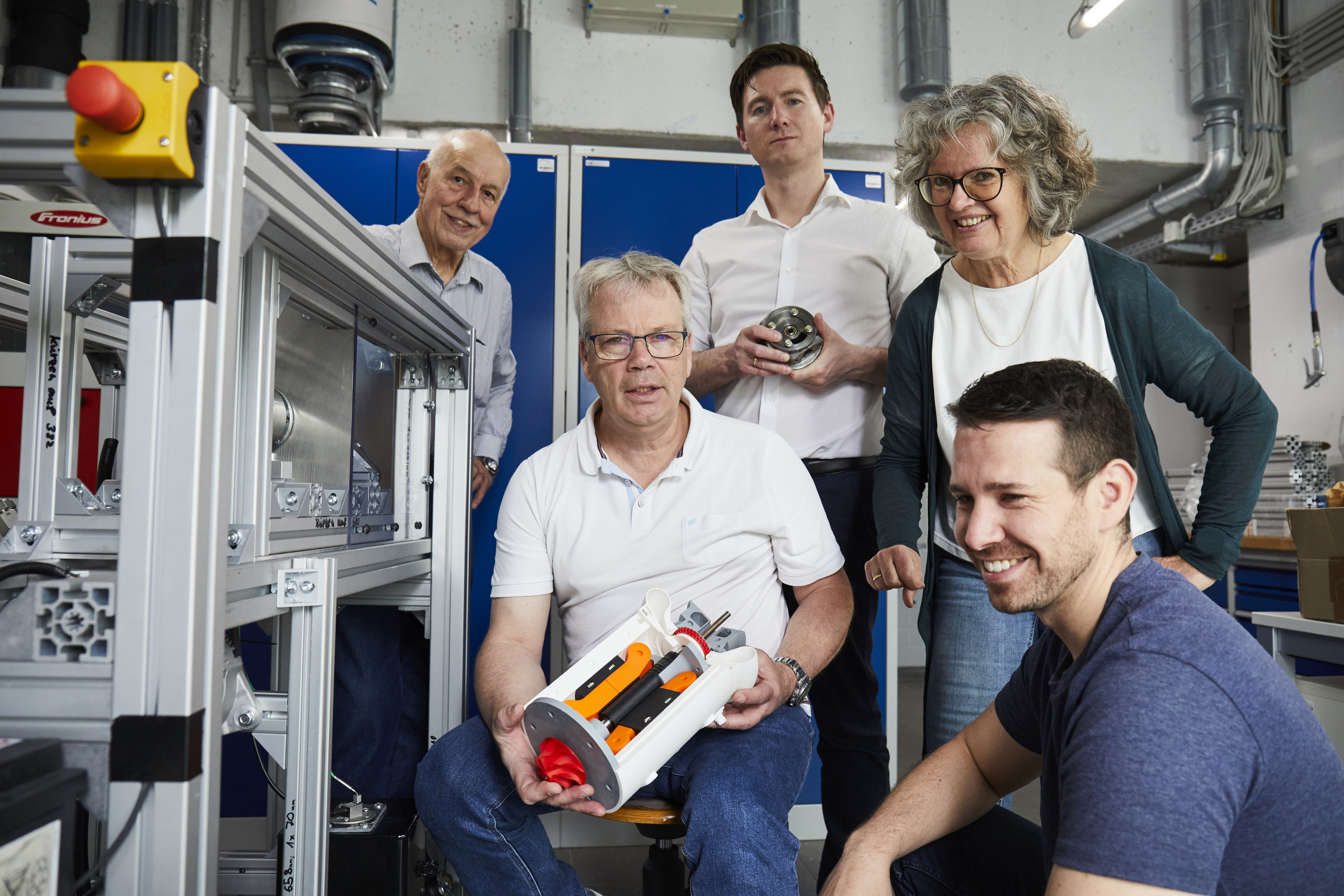 Die Turbinen-Gruppe im Labor, einzelnen halten das Anschauungsmodell oder Einzelteile der Turbine in der Hand