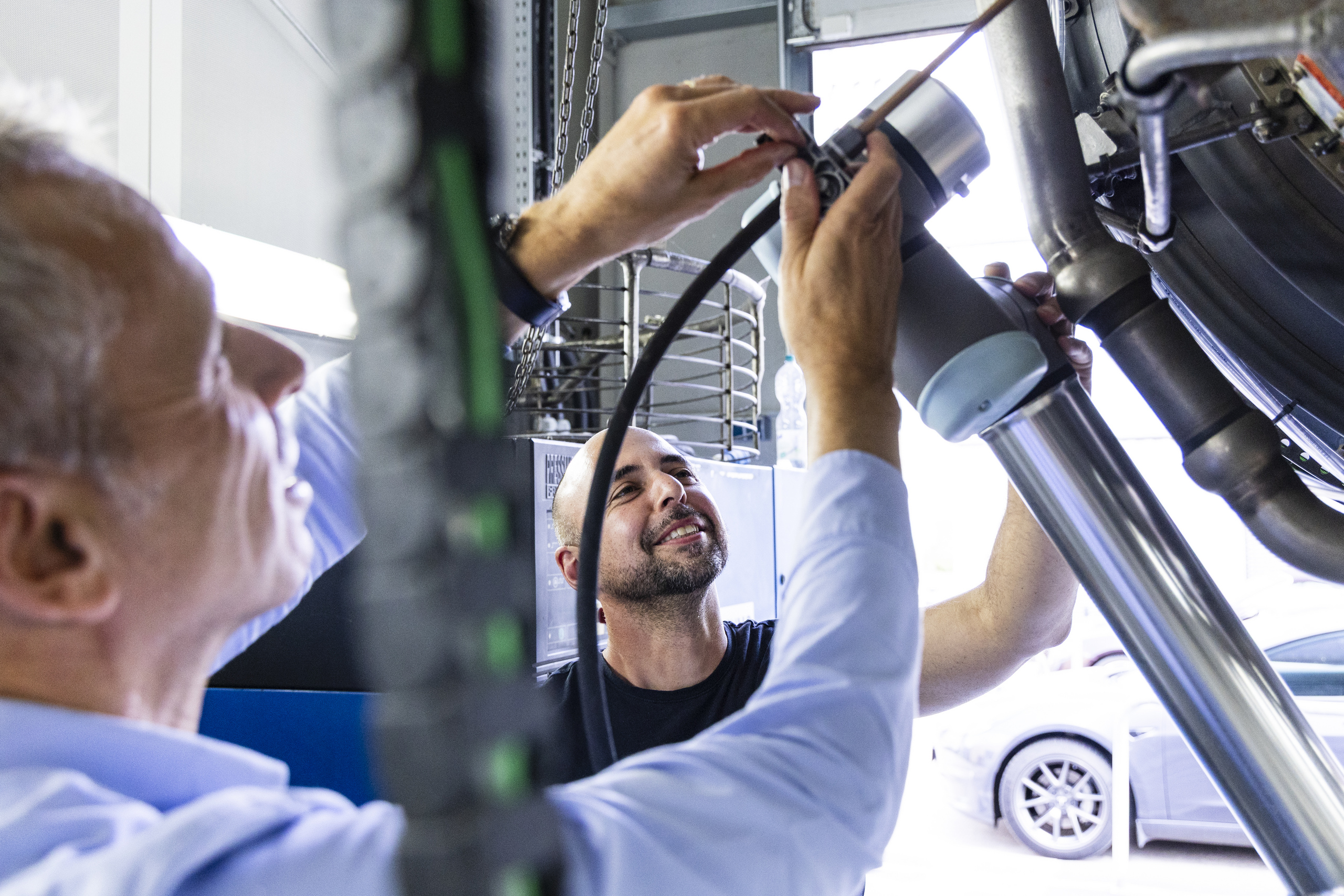 Prof. Ruß und ein Mitarbeiter arbeiten an der Turbine