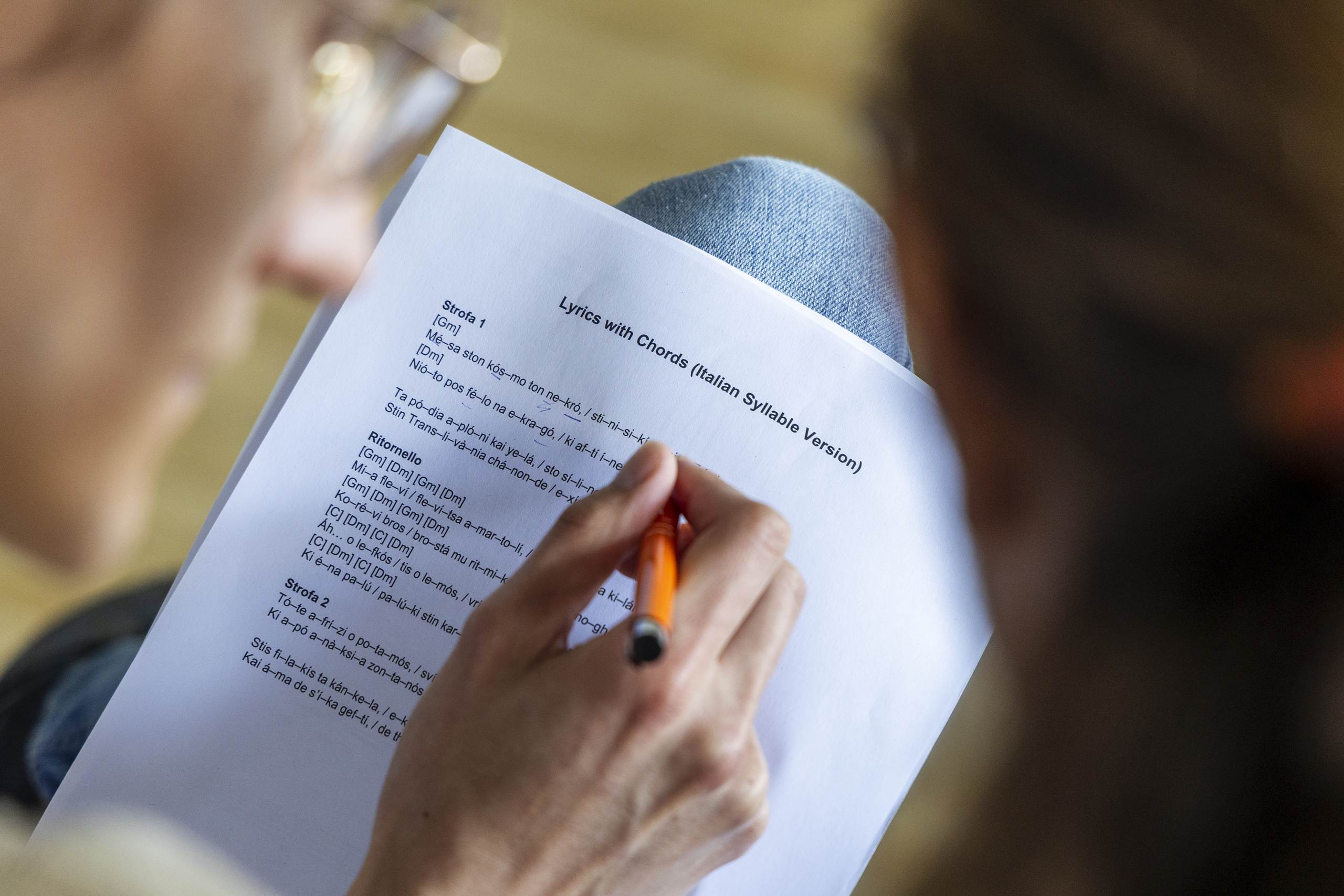 Blick über die Schulter eines Chorsängers auf ein Textblatt mit itaienischen Silben.