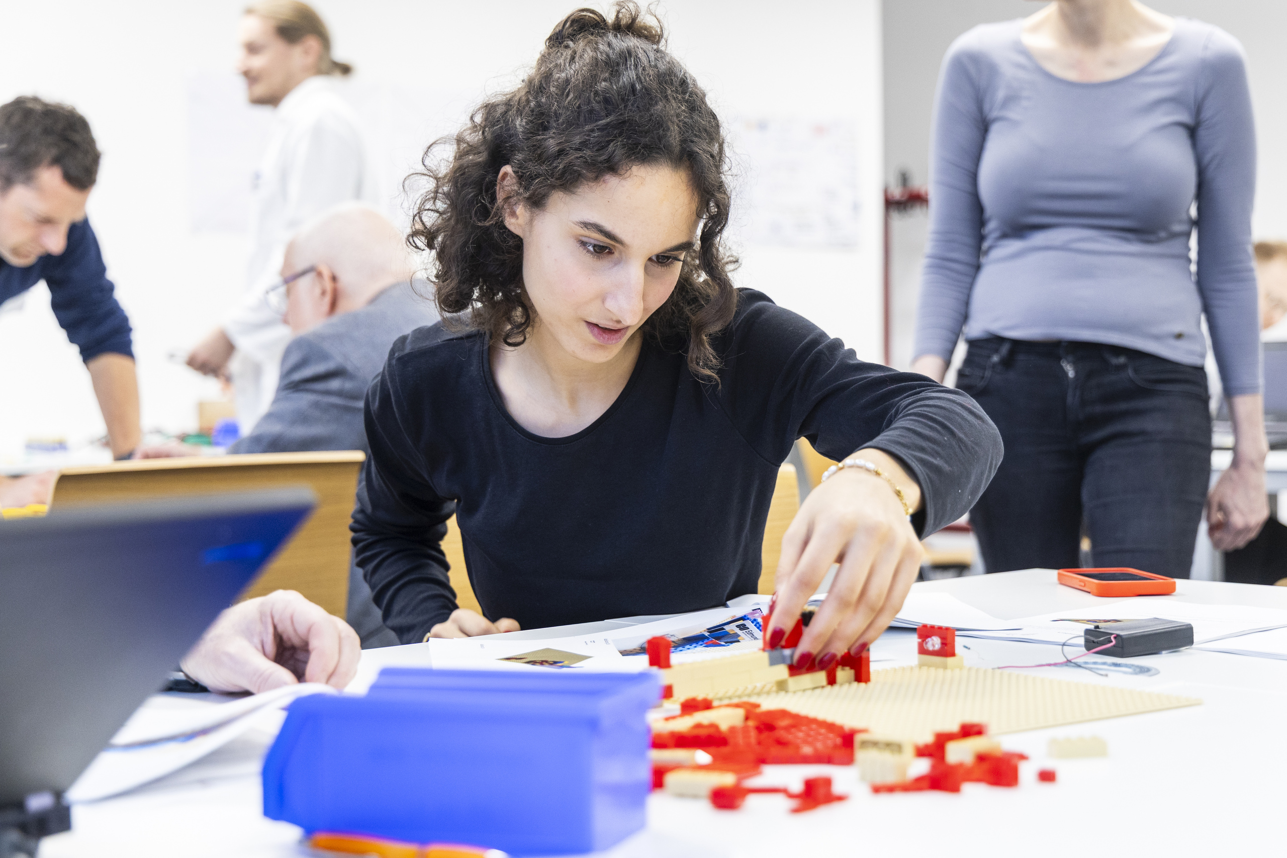 Junge Frau konstruiert mit roten Legosteinen
