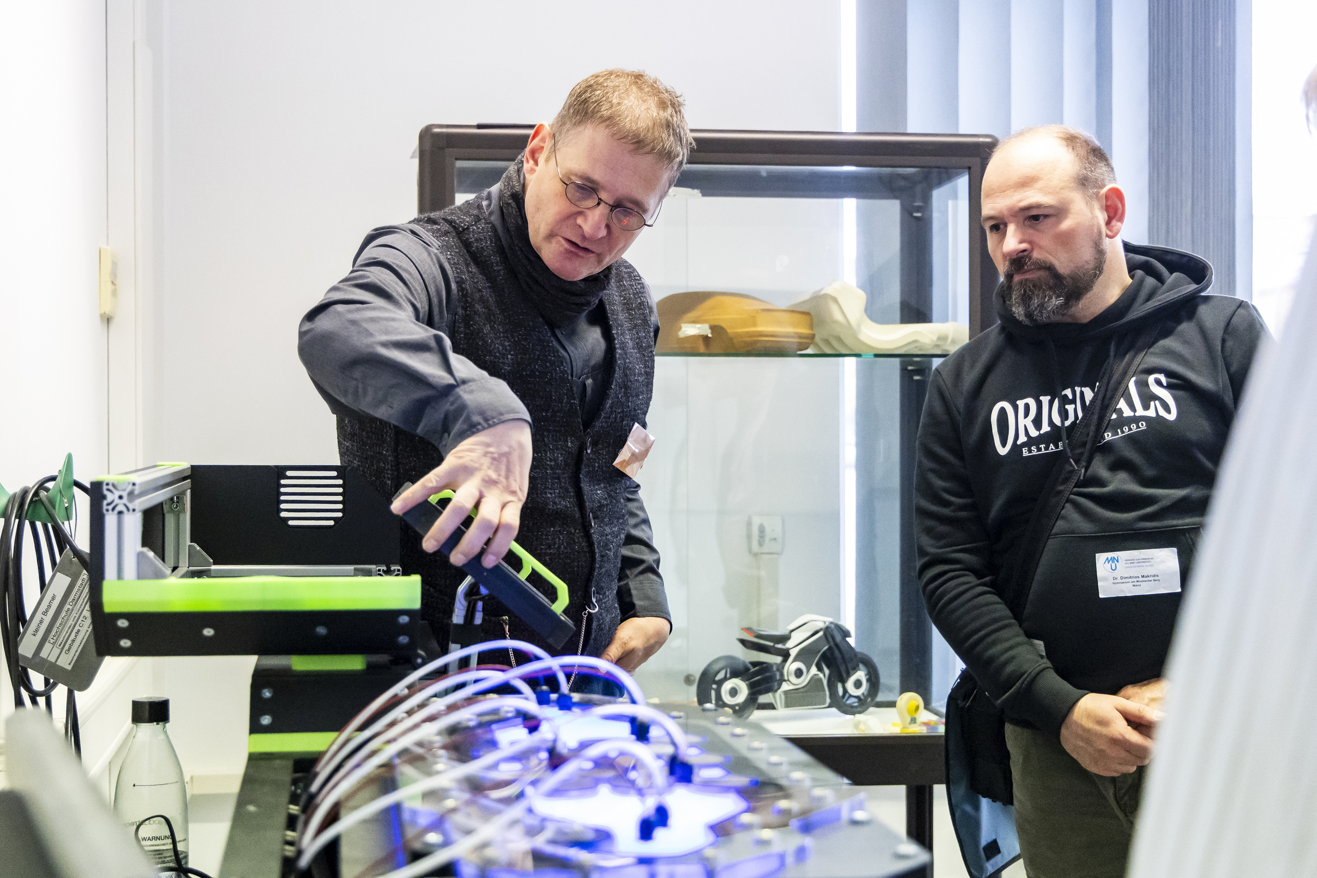 Professor Grönsfelder erläutert einem Workshopteilnehmer einen Versuchsaufbau.