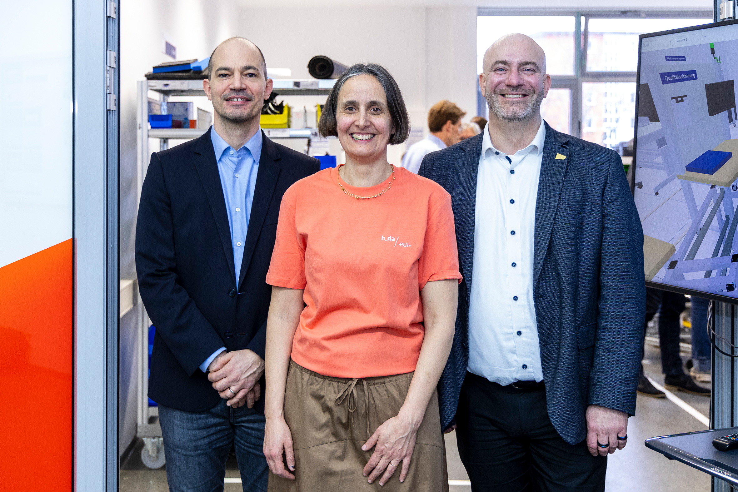 Gruppenfoto mit den drei Team-Leitenden, die freundlich in die Kamera lächeln
