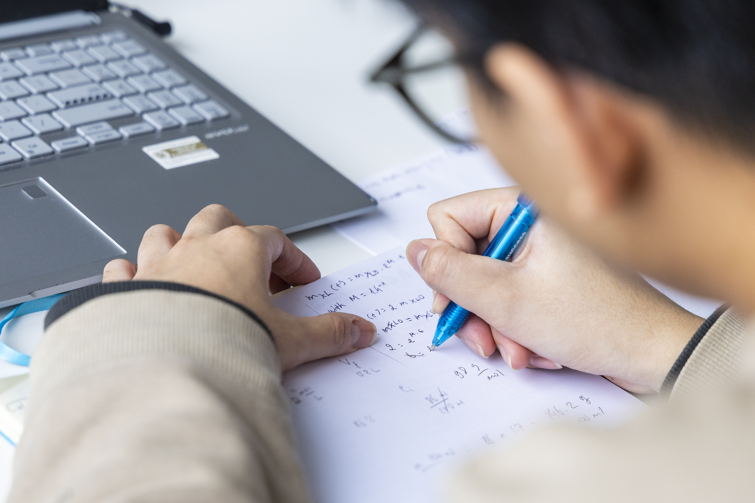 Blick über die Schulter eines Studierenden beim Schreiben