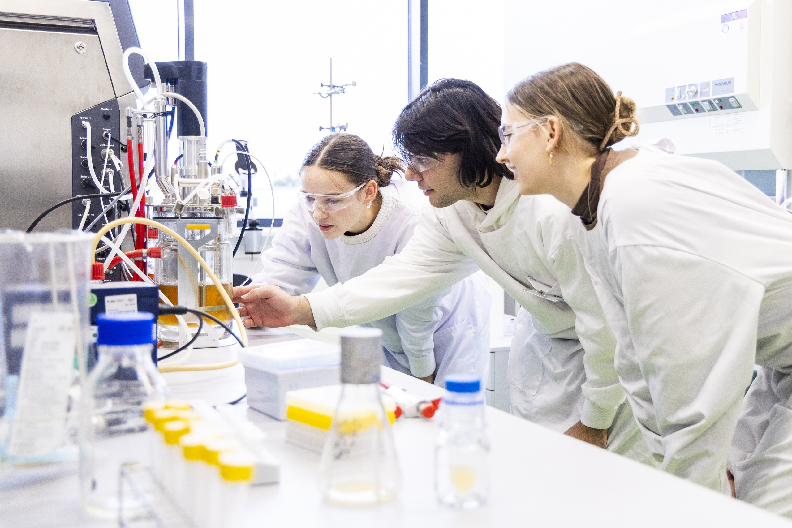 Studierende beugen sich im Chemielabor über einen Versuchsaufbau