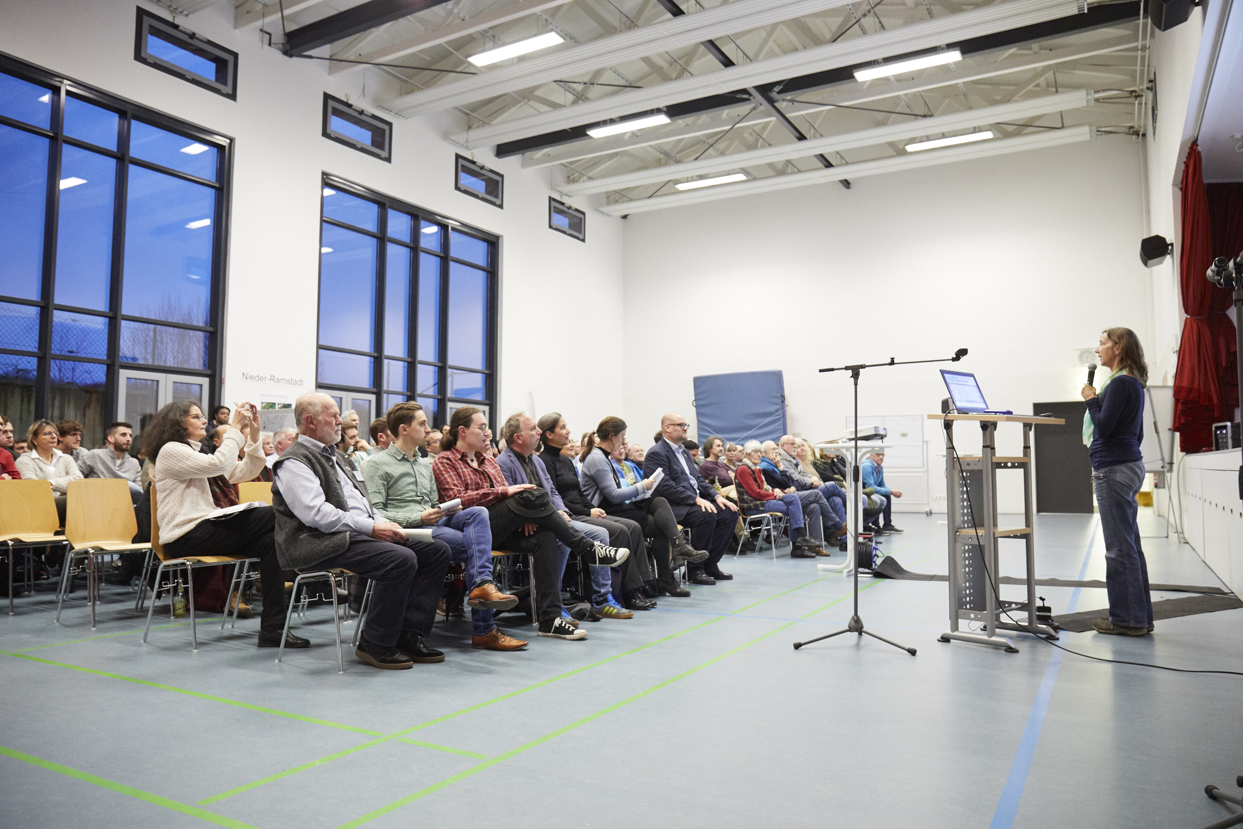 Bürgersaal mit gut gefüllten Stuhlreihen, vorne am Rednerpult eine der beiden Professorinnen
