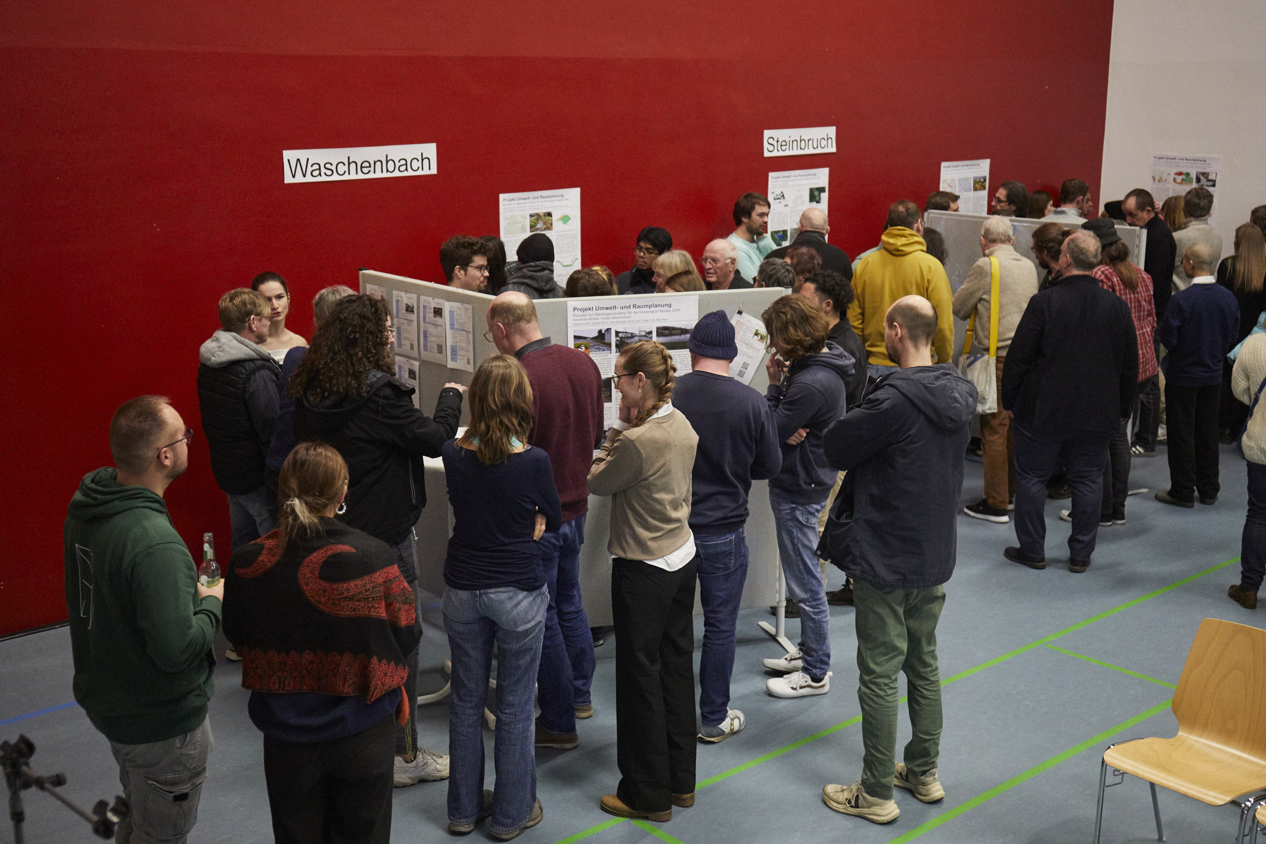 Viele Menschen stehen bei der Bürgerversammlung zum Thema Starkregen in Frankenhausen um die Präsentationswände von h_da-Studierenden herum und diskutieren
