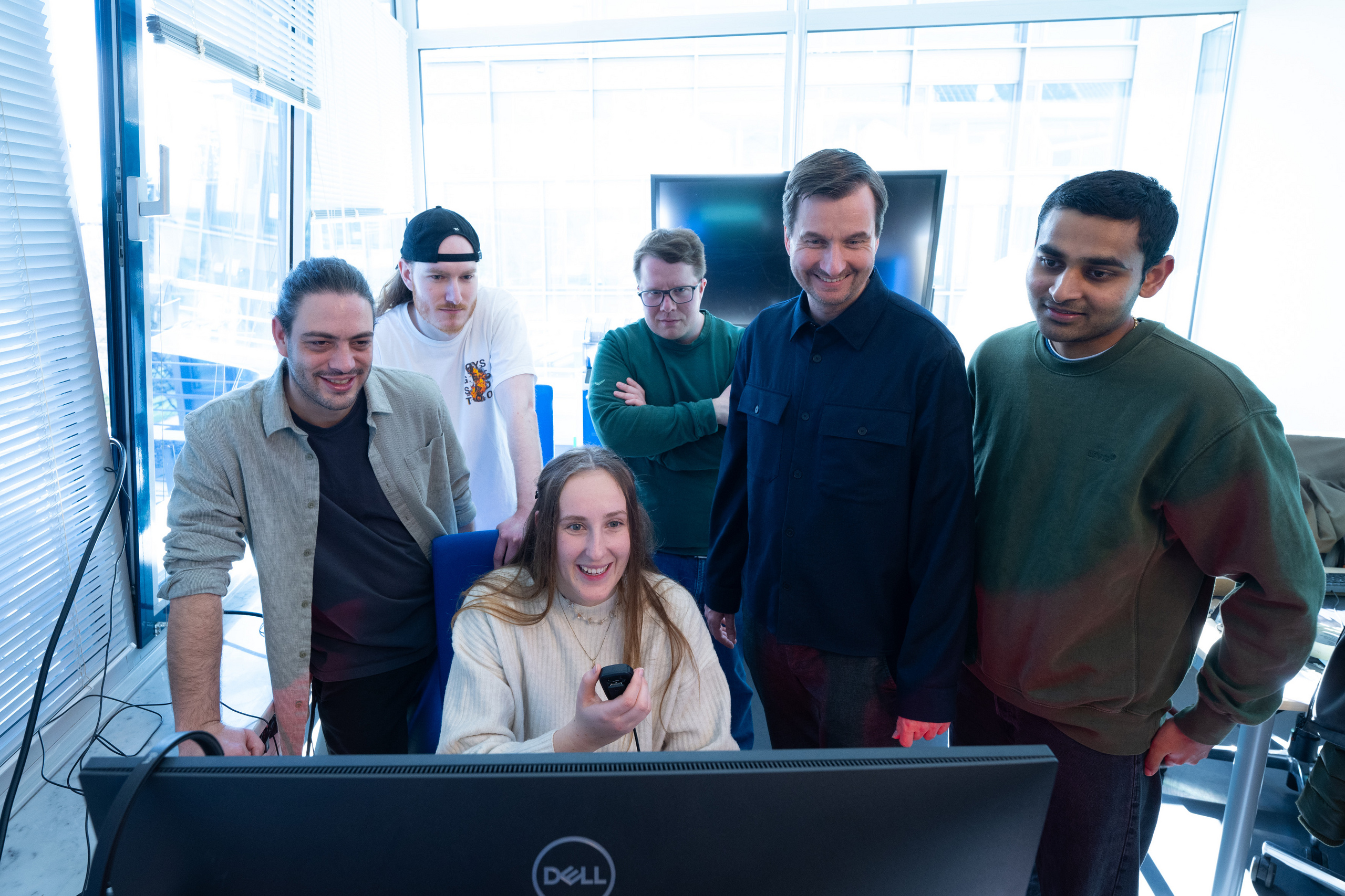 Gruppe der BIP-Beteiligten steht vor einem Computerbildschirm und setzt einen Funkspruch ab. 