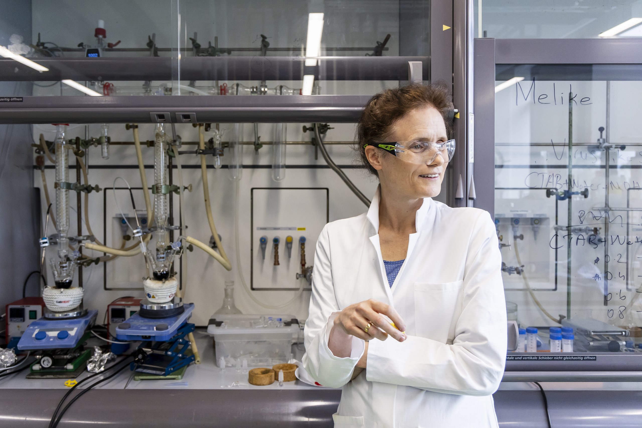 Professorin Graf im weißen Laborkittel vor einem Abzug im Chemielabor