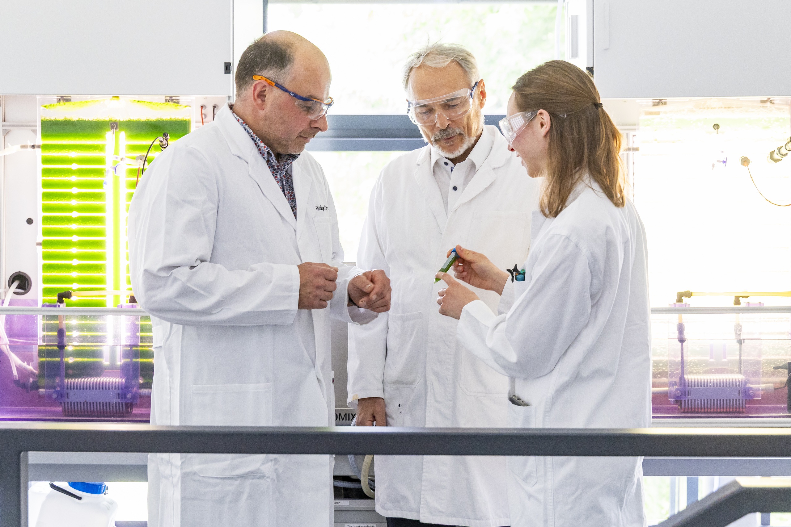 Prof. Rüdiger Graf, Dr. Gerd Klock und Doktorandin Samira Reuscher in weißen Laborkitteln