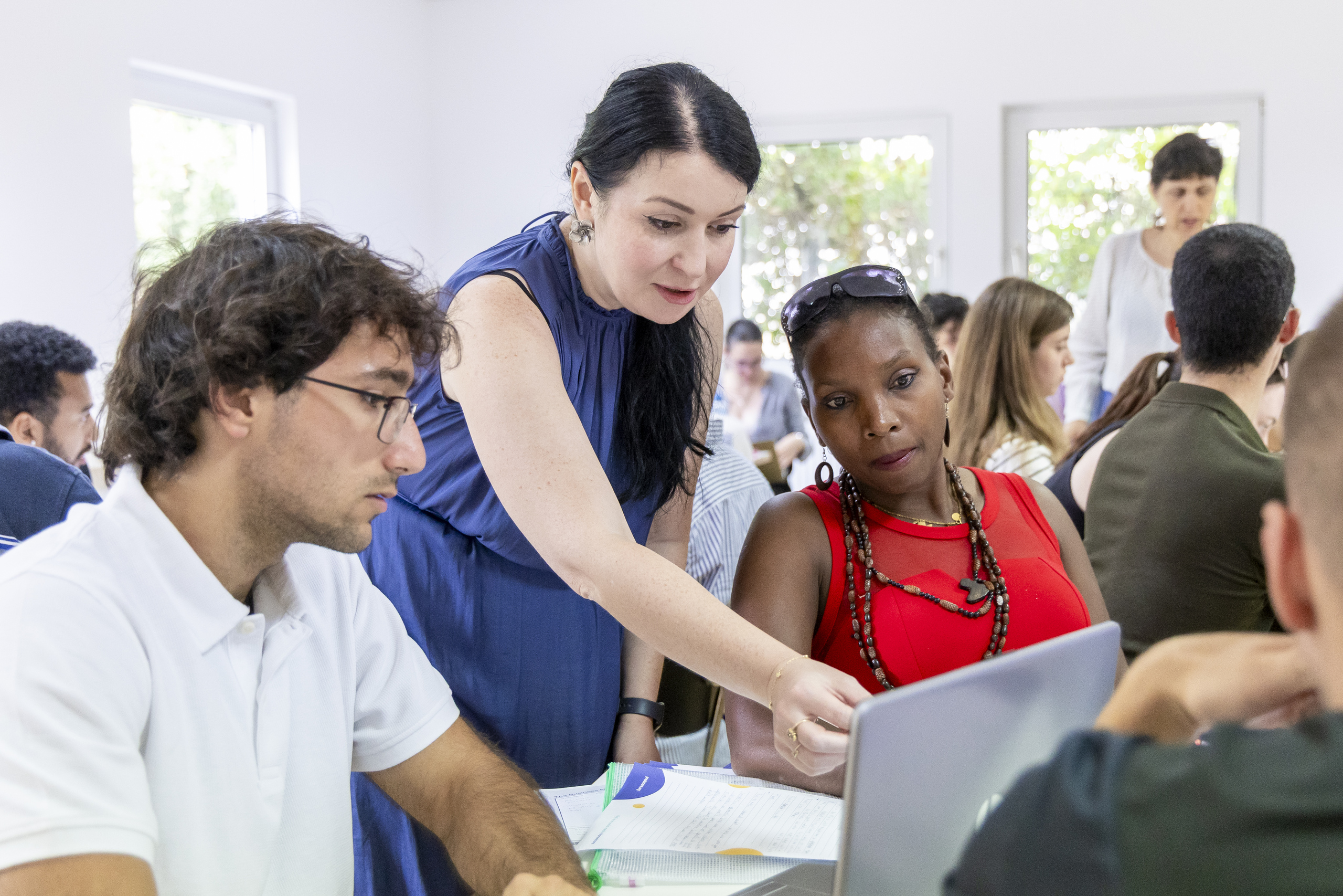 A lecturer in conversation with students in the seminar room
