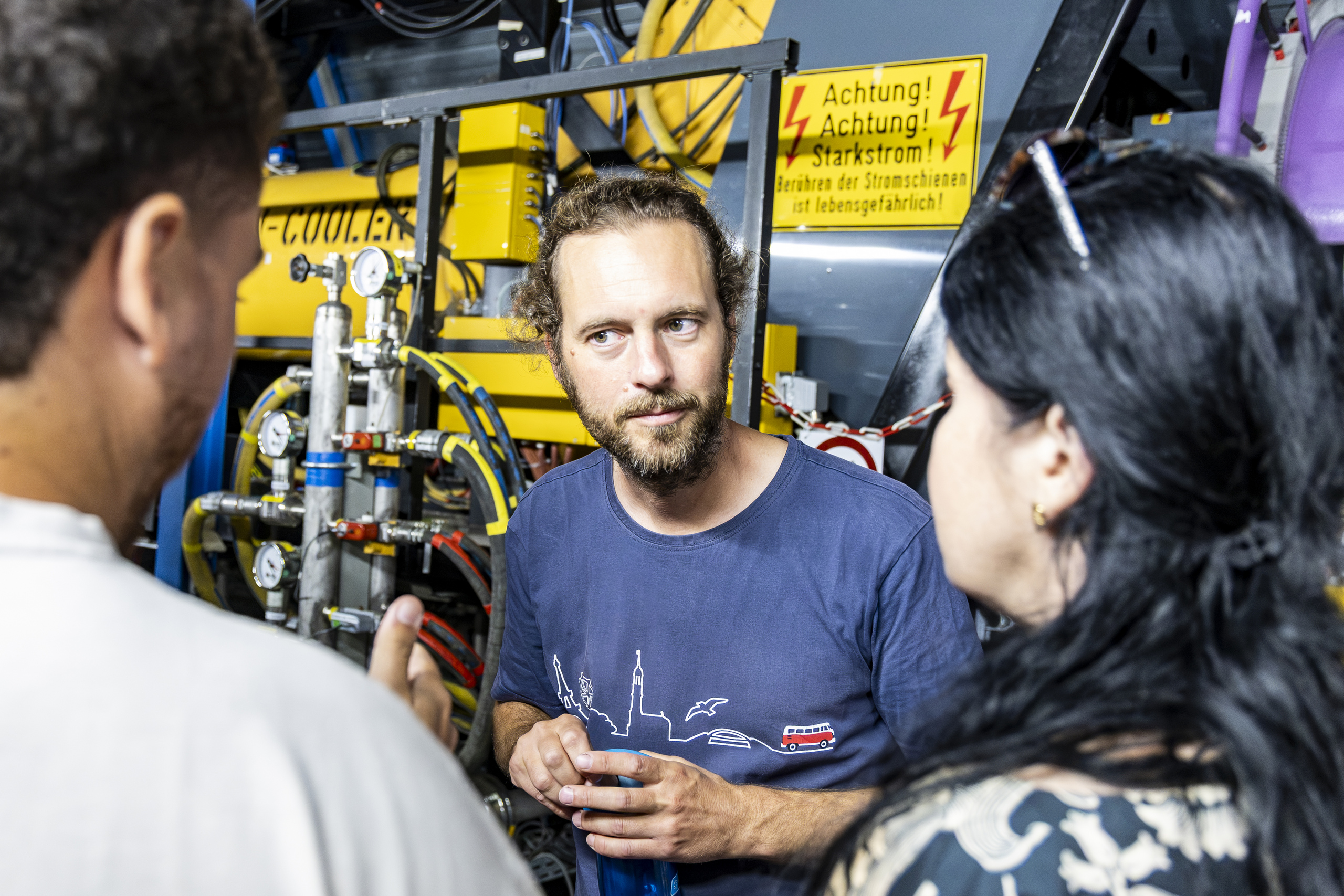 Two students in conversation with a GSI member of staff