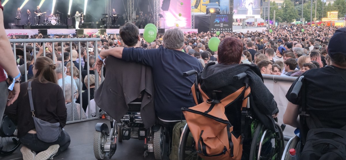 Rolli-Fahrer, die sich umarmen, beim Schlossgrabenfestival