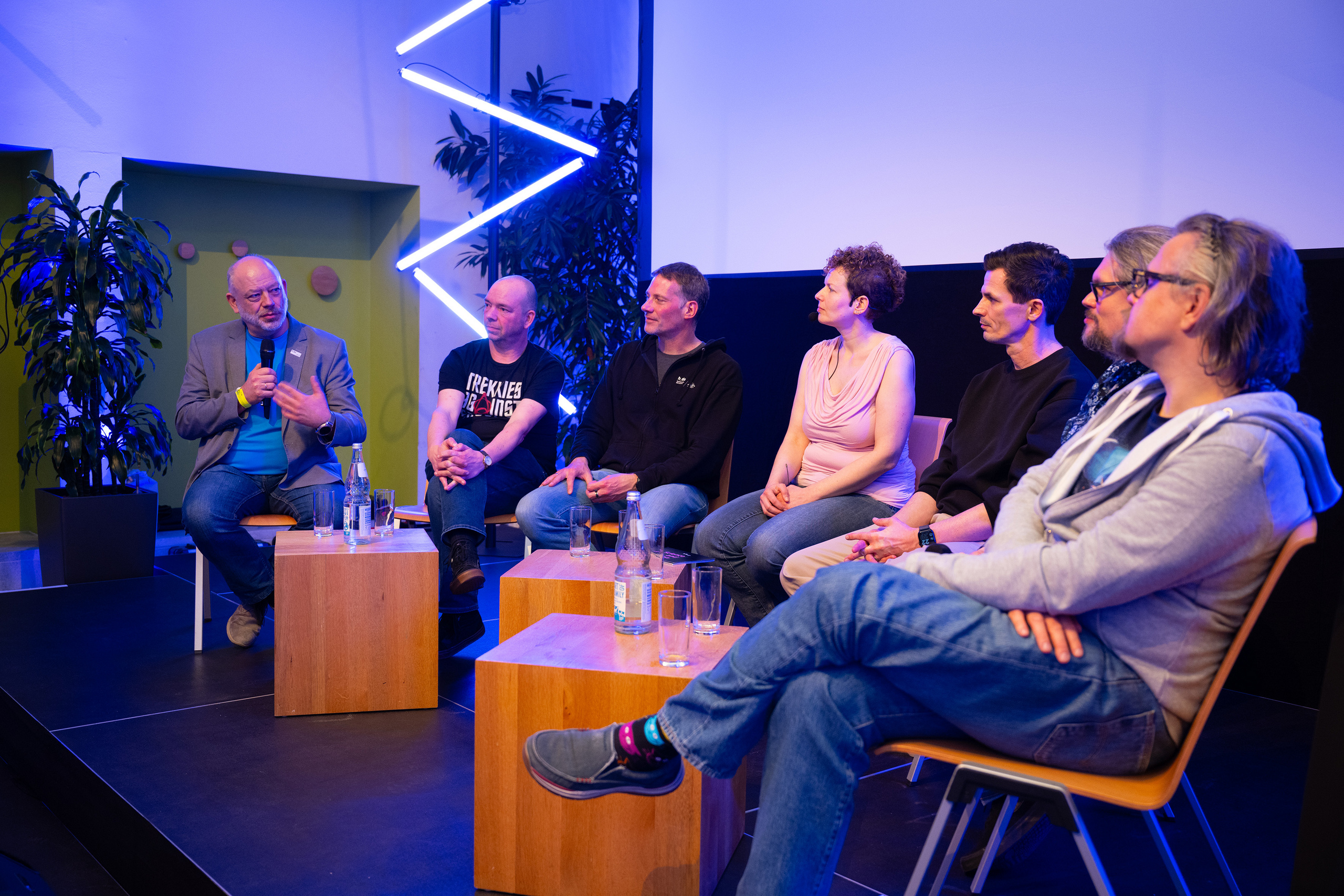 Panelisten auf Holzstühlen im Halbrund