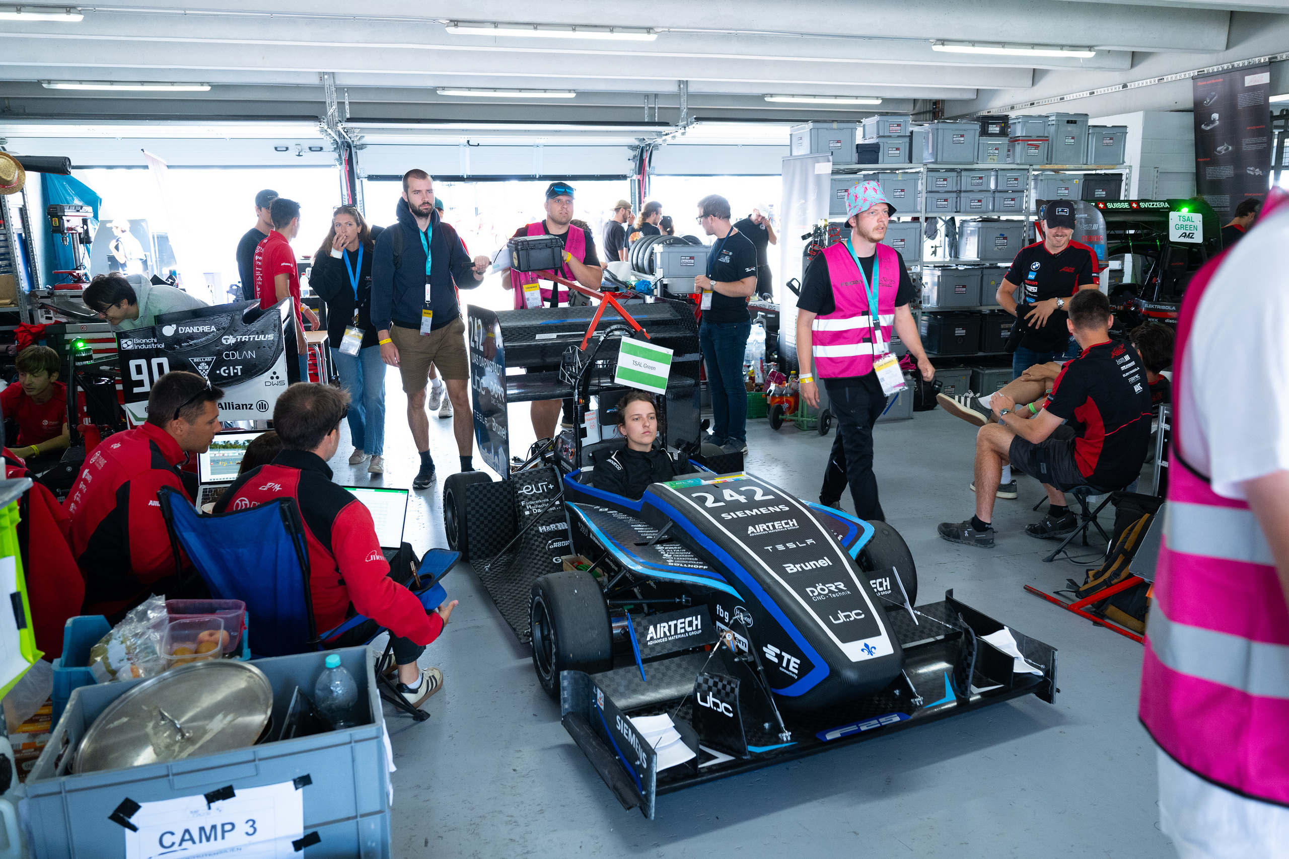 Teamfoto rund um den Rennwagen im Pit
