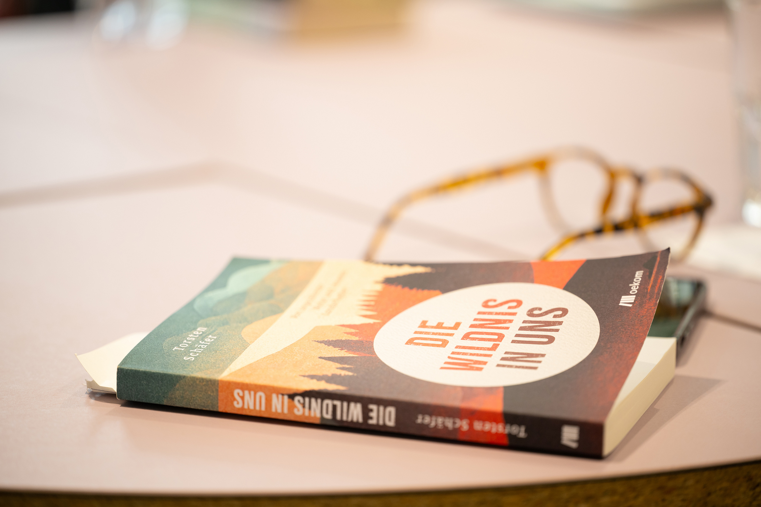 Buch und Brille auf einem Tisch